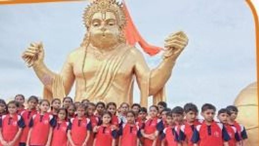 Students standing in front of a large statue during an educational visit