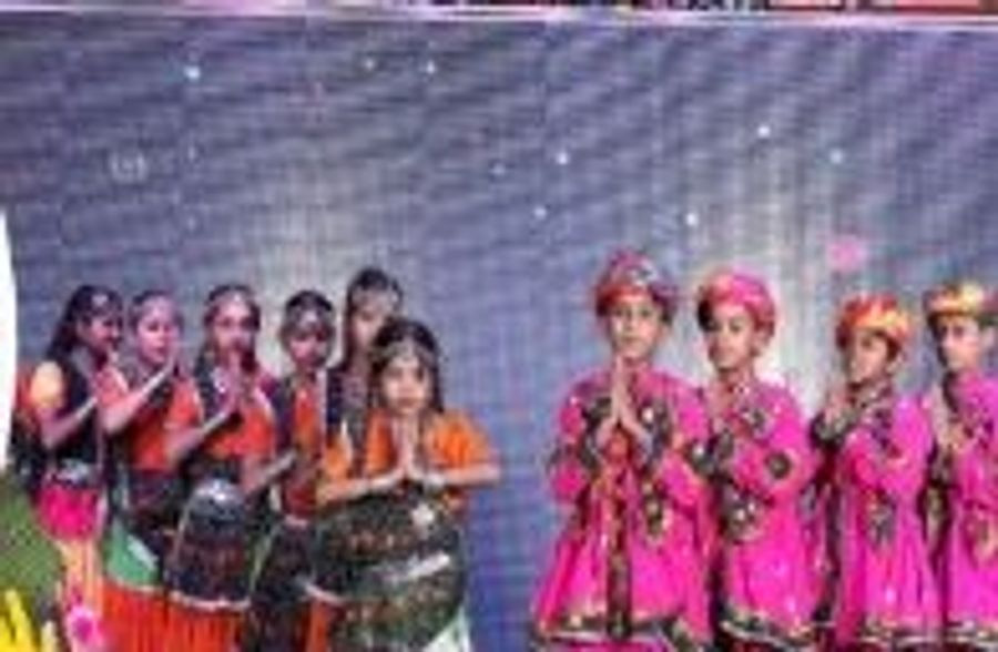 A group of young dancers in colourful costumes performing together on stage