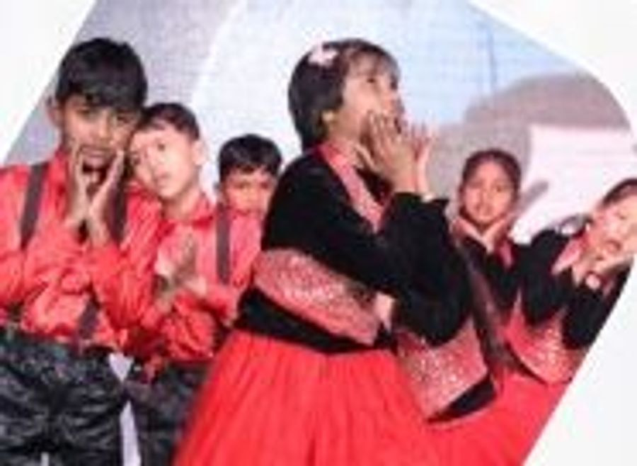Students in red and black costumes performing a skit on stage